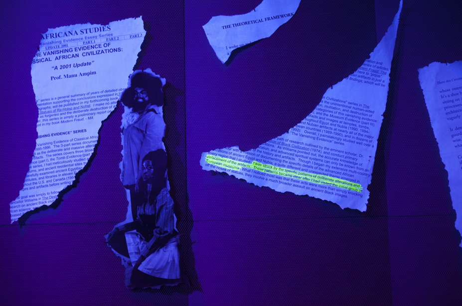 Scraps of paper underneath a black light with a glowing highlight