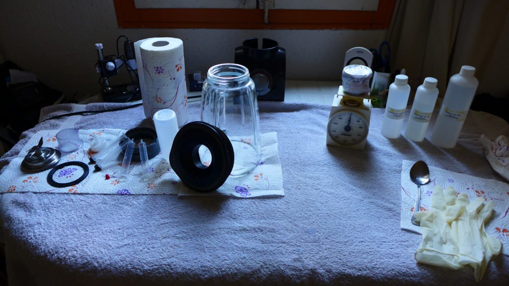 a photograph of a table with bottles, a blender and paper towels