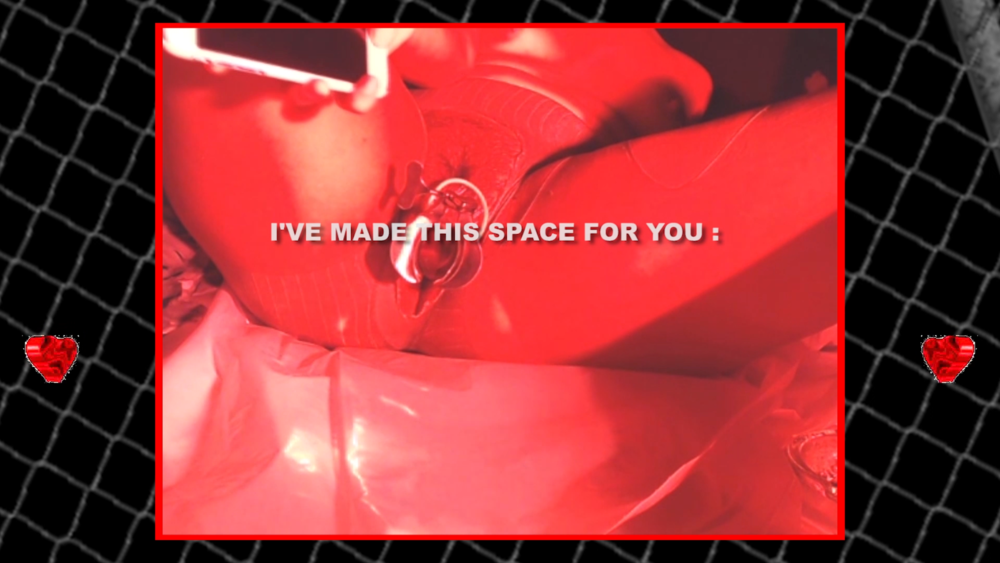 video still of a monotoned red image a body with legs spread showing an open vulva sitting on top a gridded black background