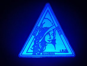 a photograph of a glow-in-the dark triangle-shaped patch of Lena, a playmate who is looking over her shoulder
