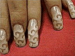 A photo of long nails with a brown to white gradient showing oriental cloud and wave patterns.