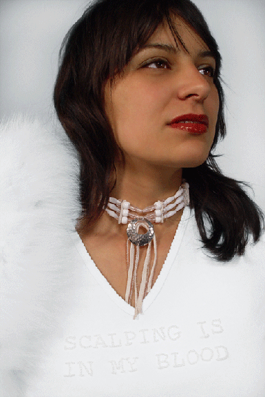portrait of an indigenous women wearing all white wearing an ornate necklace