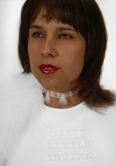 portrait of an indigenous women wearing all white wearing an ornate necklace