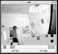 Vintage GUI of a media player showing a low resolution image of a man wearing a collared shirt and dark pants walking into a room and closing the door behind him.