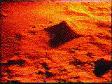 A low-resolution image of a vibrant burning orange, sandy, and rocky terrain with a blazing yellow glow that comes from the shine of a bright sun or star.