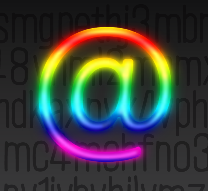A glowing holographic rainbow "at" sign in front of a grey background with a random assortment of typed letters and numbers.