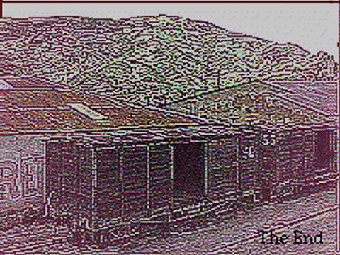 A low quality image of light wooden structures and buildings meeting the mountainous landscape. "The End" is typed in black on the right corner.