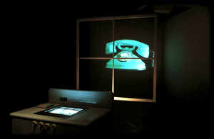 A 3D graphic image of a dark room with a stove top and a screen displaying an image on the induction oven. Behind is a large square window frame and a vintage blue telephone projected behind.